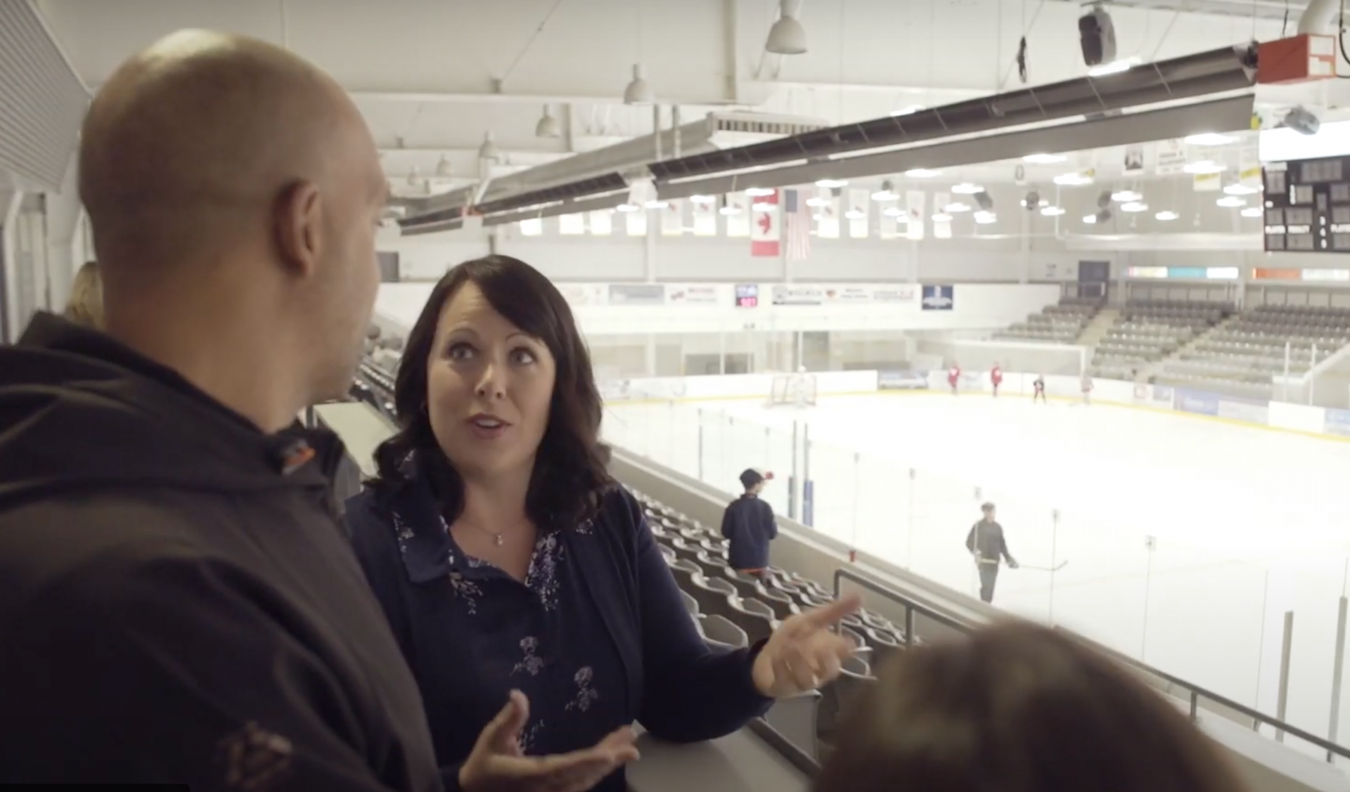 Two individuals talking in the stands of an arena